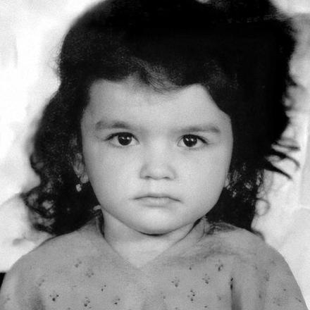 Ilona as a little girl, with a cloud of dark curls